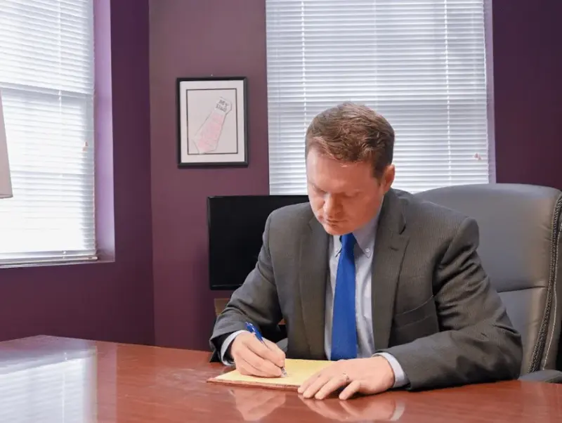 Tate Meagher writing at his desk